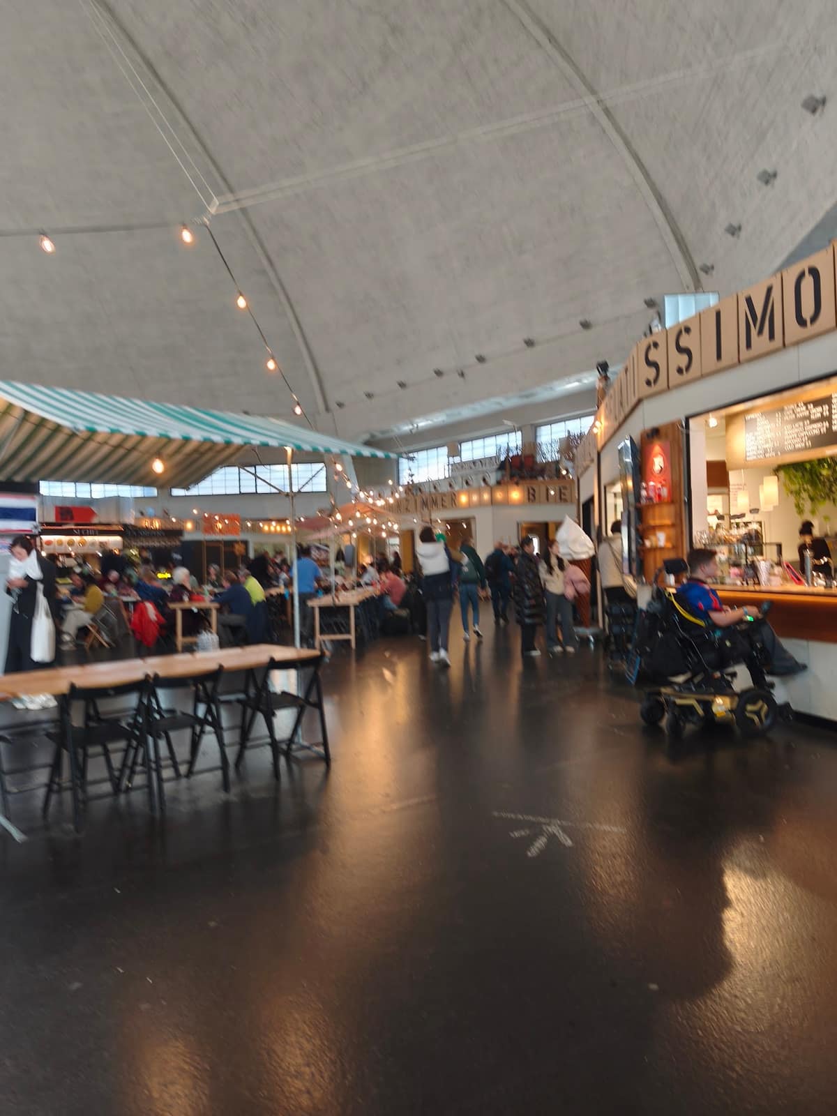 Die Stände und langen Tische unter der Kuppel der Markthalle Basel