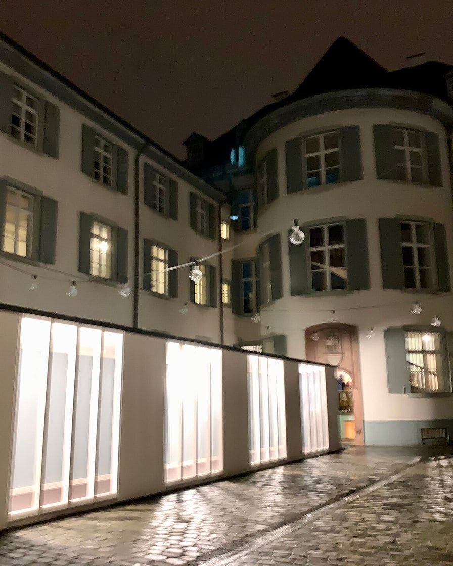 An exhibition room at the Antikenmuseum Basel looking onto the museum's courtyard