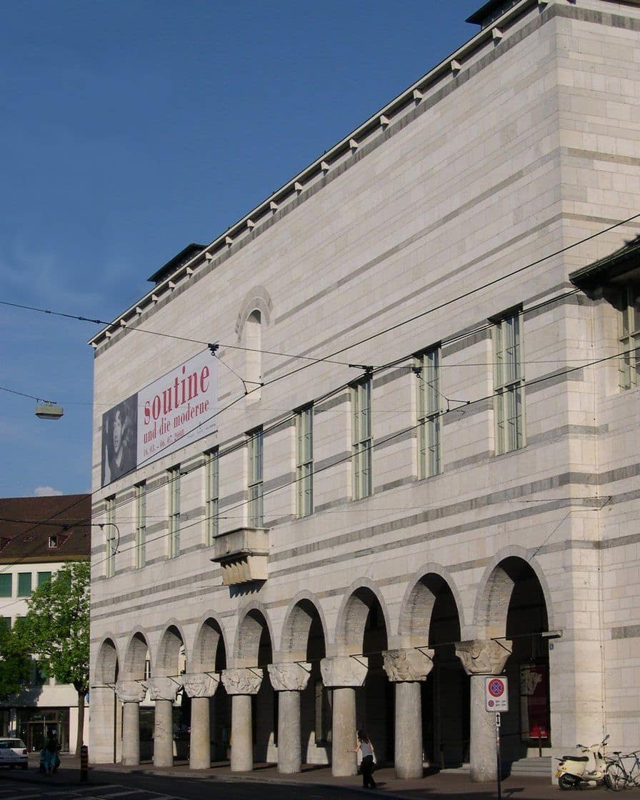 The facade of the Kunstmuseum Basel main building on St. Alban-Graben, with grey stone arcades and banners for the current exhibition