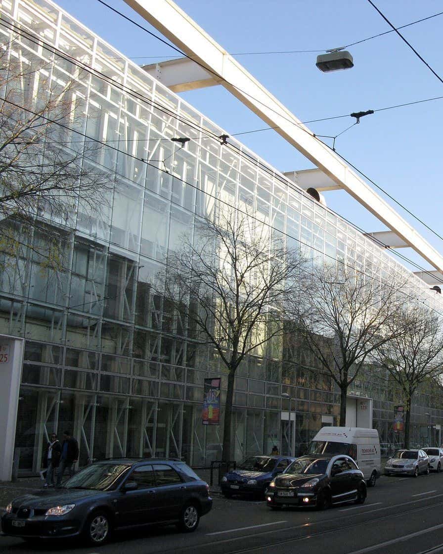 Hall 1 of Messe Basel with Herzog and de Meuron's facade of metal bands above Messeplatz, with visitors in front