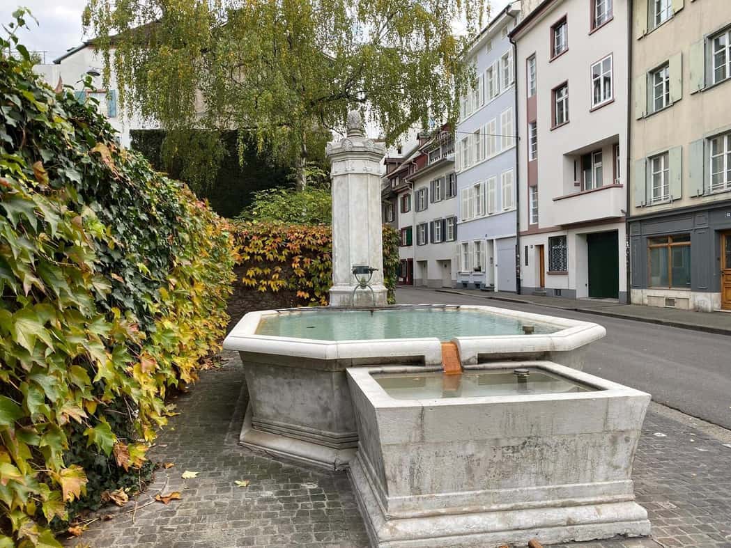 Ein Brunnen vor alten Häusern an der Rheingasse in Kleinbasel