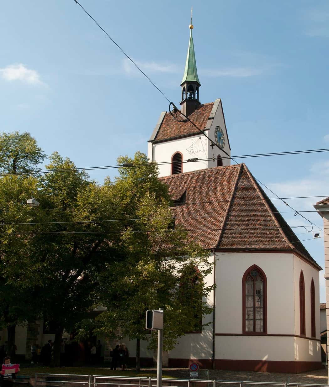 Die Dorfkirche St. Martin in Riehen mit ihrem Turm, hinter Bäumen im Dorfkern